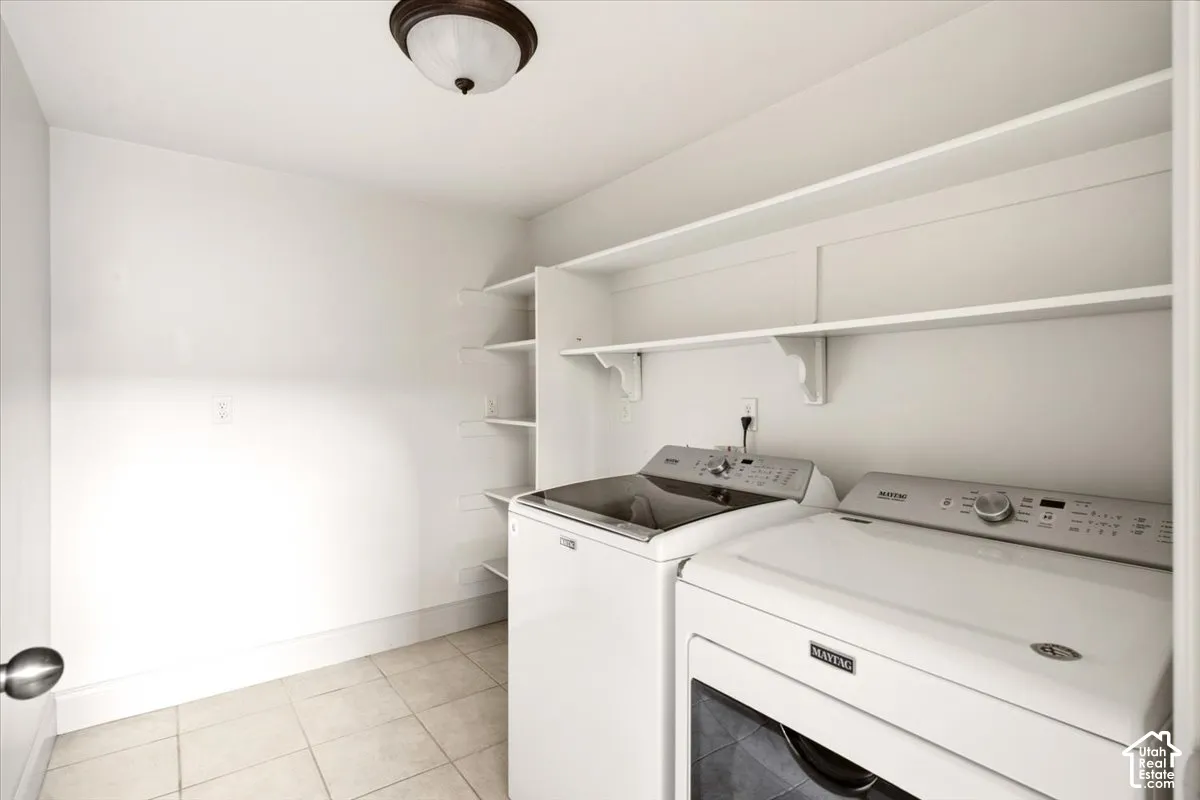 Utility room featuring tile flooring, built-in shelving, and a ceiling-mounted light fixture