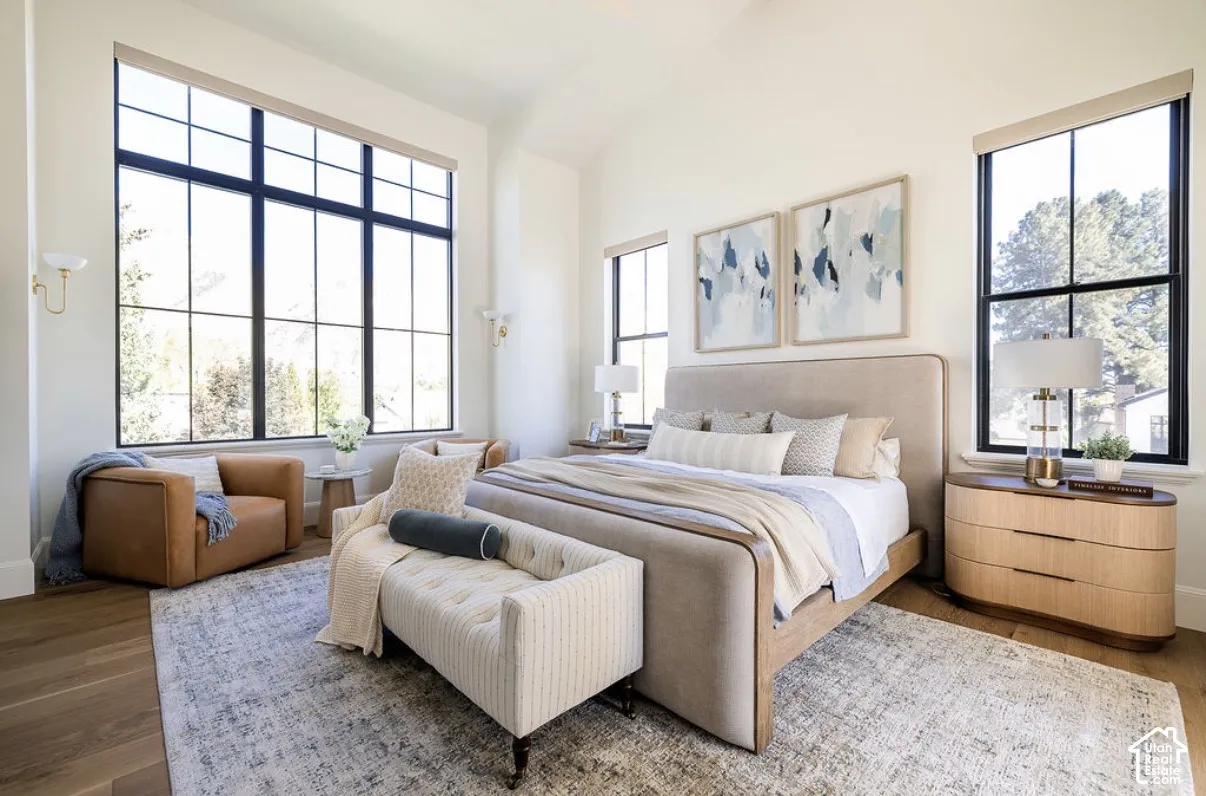 Vaulted ceilings, expansive windows with black mullions, and wood-finish flooring