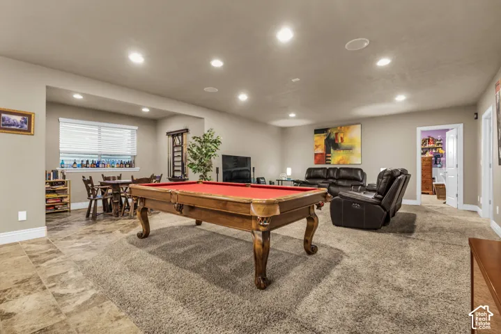 Open-concept interior featuring recessed lighting, large-format tile flooring, wall-to-wall carpeting, and multi-pane windows