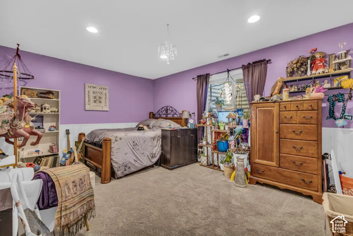 Interior room featuring wall-to-wall carpeting, wainscoting, recessed lighting, and a decorative pendant fixture