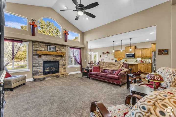Vaulted ceilings, stone-surround fireplace with timber mantel, arched windows, and wood-finish cabinetry