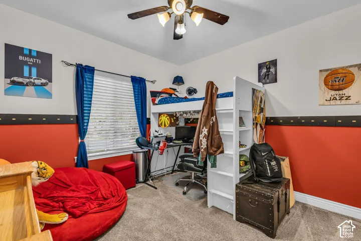 Room featuring neutral-toned carpeting, two-tone wall finish, window with horizontal blinds, and a multi-light ceiling fan