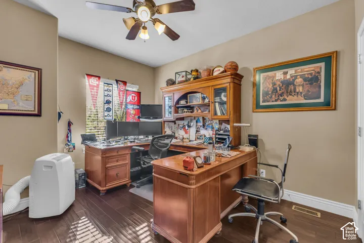 Room featuring wood-finish flooring and a multi-blade ceiling fan with integrated lighting