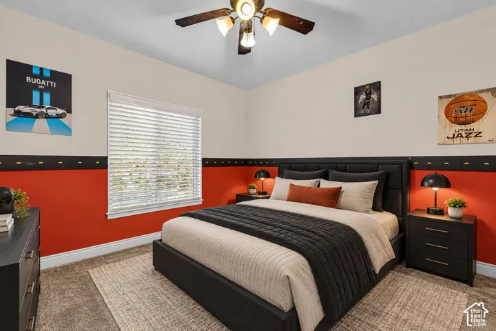 Bedroom featuring neutral-toned carpeting, two-tone interior paint, horizontal window blinds, and a multi-bulb ceiling fan