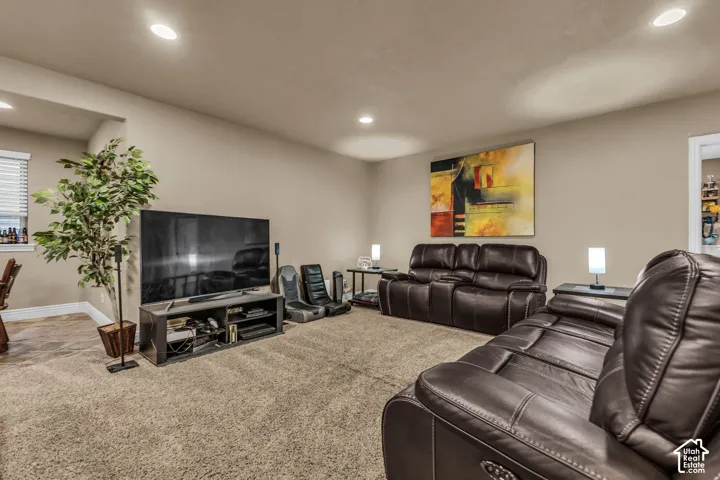 Neutral-toned interior room featuring recessed ceiling lighting, wall-to-wall carpeting, and a window with horizontal blinds