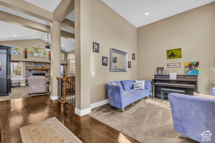High ceilings with recessed lighting, dark wood-finish flooring, and metal railing staircase featuring wooden handrails