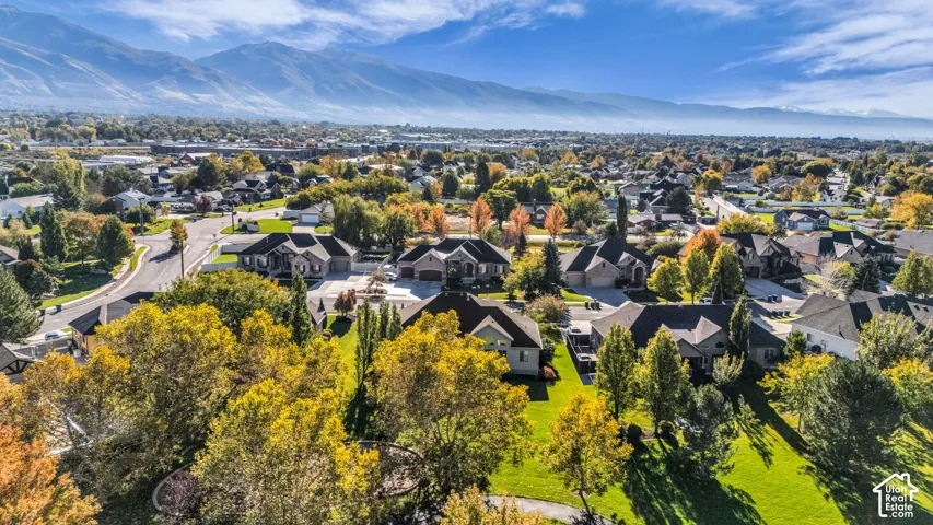 Aerial perspective featuring expansive residential grounds, mature landscaping, and an extensive mountain backdrop