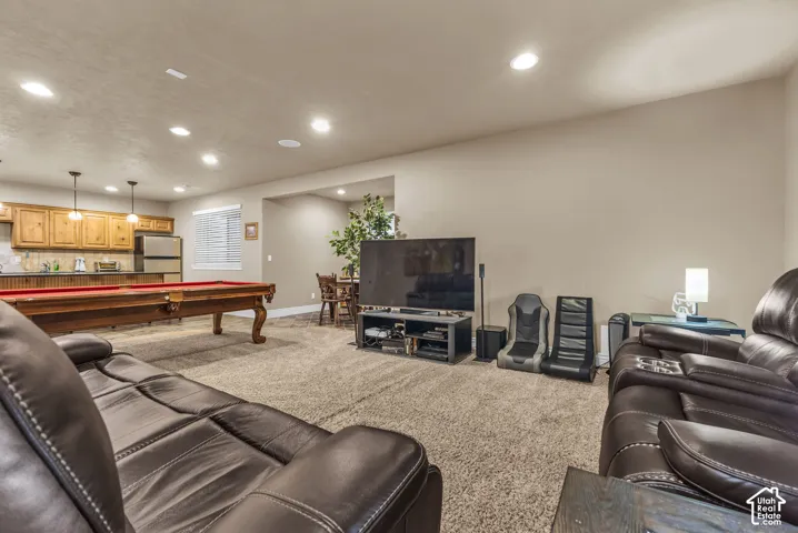 Recessed lighting, wood cabinetry with integrated sink, and neutral wall-to-wall carpeting