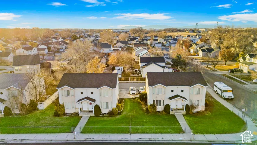 Aerial perspective of multi-family residences featuring dual-pitched rooflines, bay windows, masonry accents, and manicured front lawns