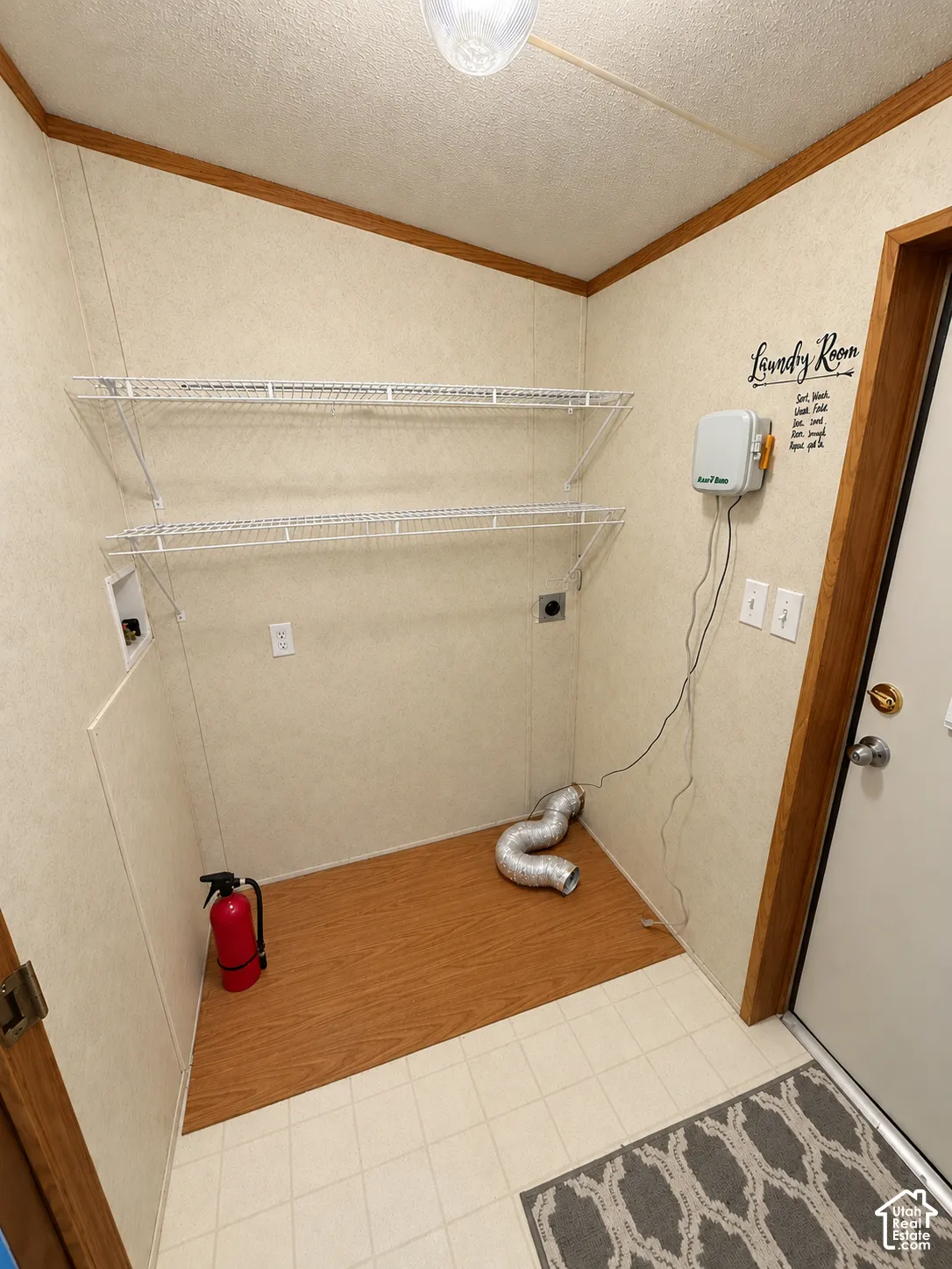 Dedicated utility area featuring wall-mounted wire shelving, wood-finish flooring, and designated washer and dryer hookups