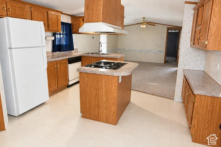 Kitchen featuring wood cabinetry, laminate countertops, a center island with an integrated cooktop, and an overhead range hood