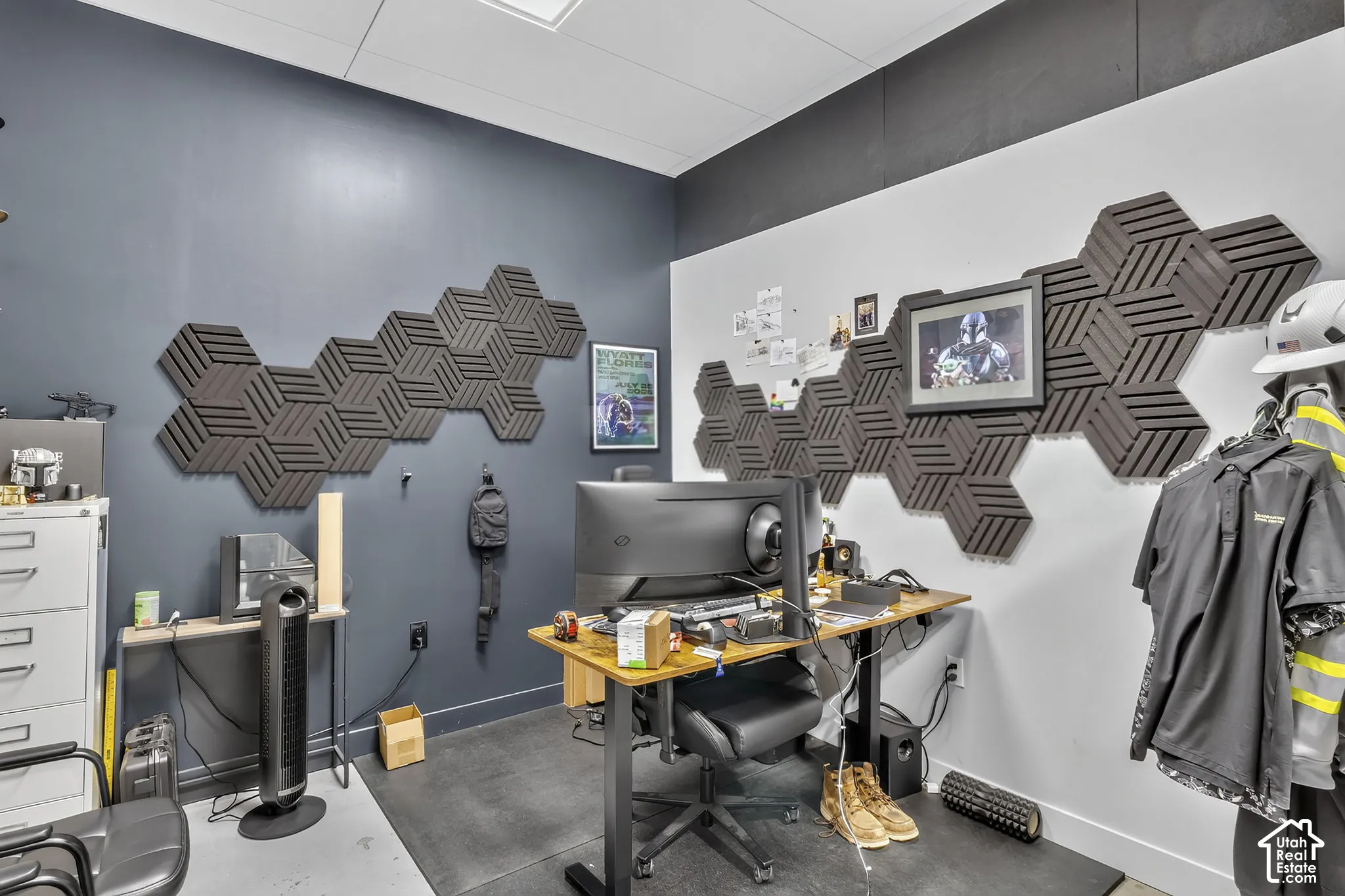 Interior room featuring charcoal-colored accent walls, decorative hexagonal wall-mounted sound-dampening panels, and high-contrast two-tone wall finishes