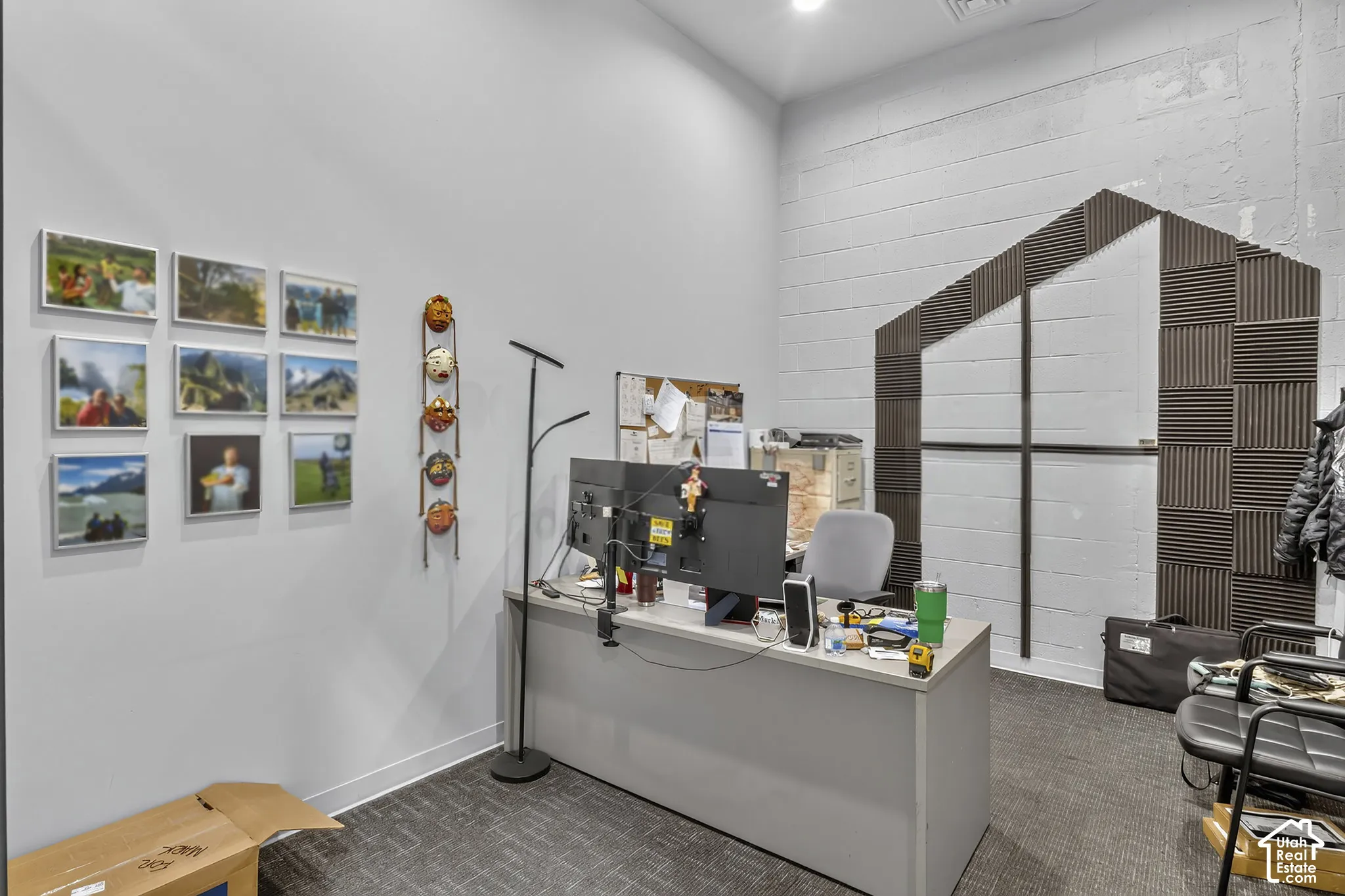 Interior space featuring high ceilings, neutral wall-to-wall carpeting, painted masonry block walls, and recessed ceiling lighting