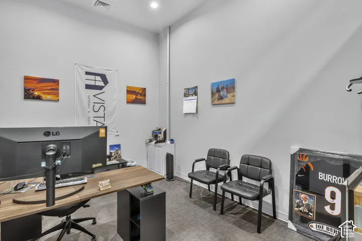 High-ceiling interior space featuring neutral wall paint, recessed lighting, and low-pile carpeting