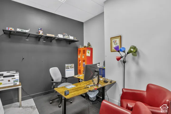 Interior room featuring a charcoal accent wall, contrasting light grey wall, and wall-mounted metal shelving