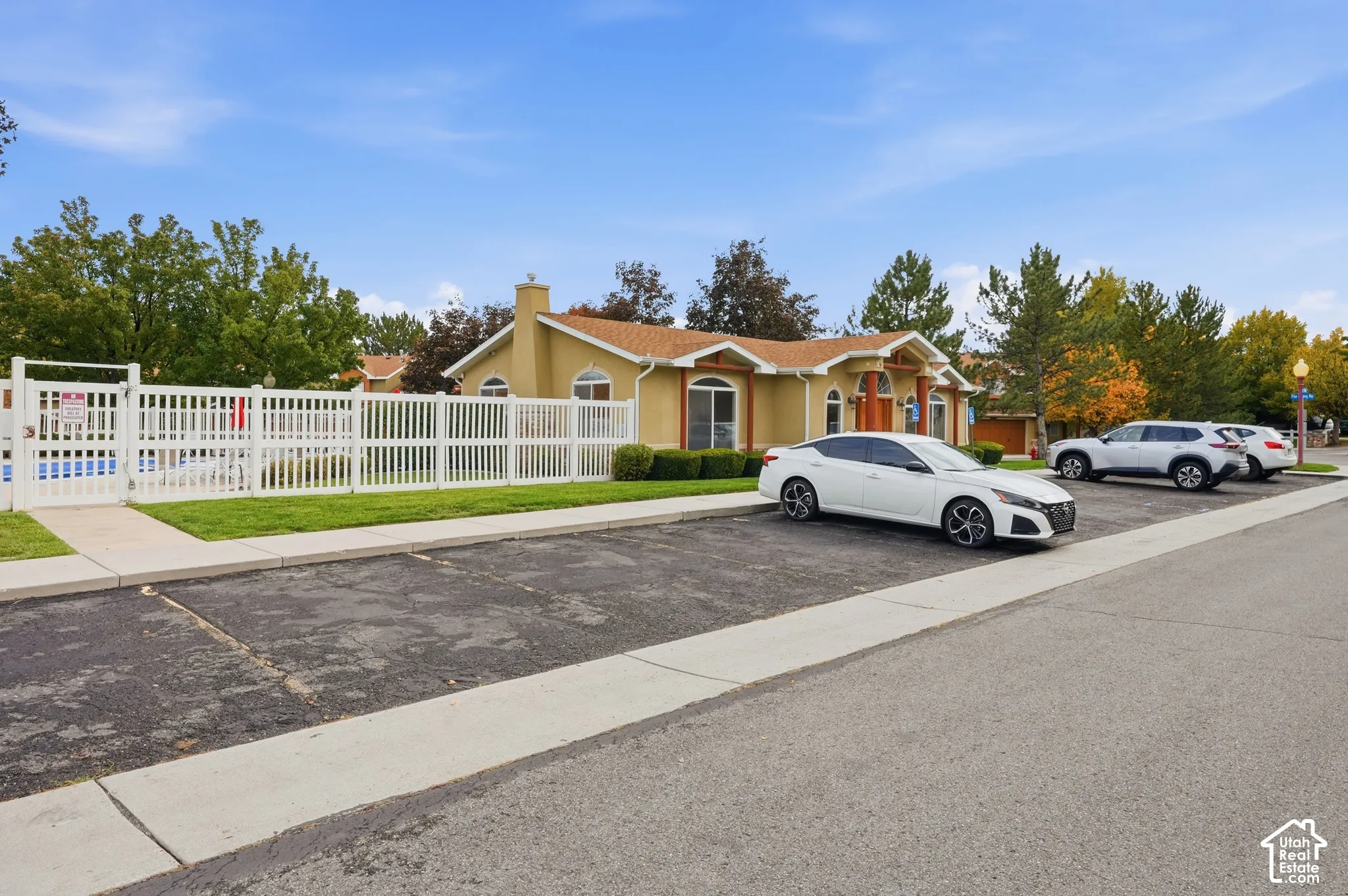 Stucco exterior featuring arched windows, a chimney, and a fenced swimming pool