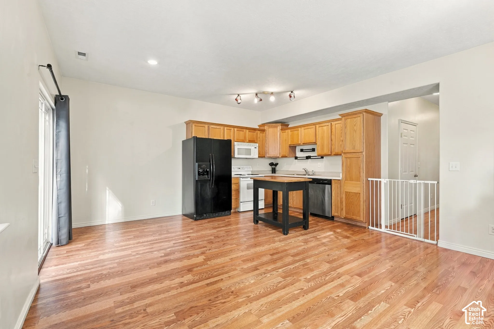 Kitchen featuring wood-finish cabinetry, wood-finish flooring, recessed lighting, and a sliding glass door