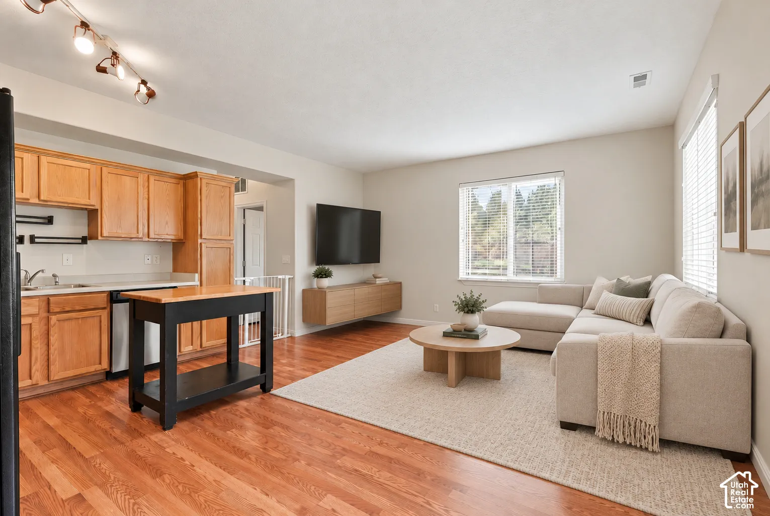 Kitchen featuring wood cabinetry, wood-finish flooring, and multi-directional track lighting