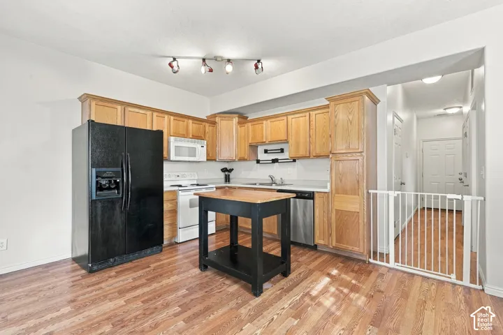 Kitchen featuring wood cabinetry, wood-finish flooring, track lighting, and a kitchen island with a wood surface