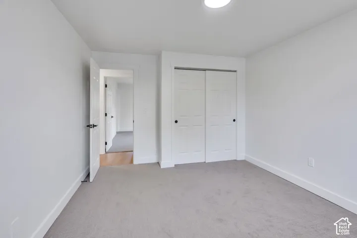 Neutral-toned wall-to-wall carpeting, six-panel sliding closet doors, and crisp white interior doors with dark hardware