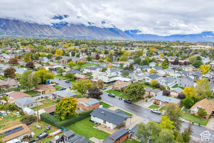 Aerial perspective featuring residential lots, mature trees, and a mountain range backdrop