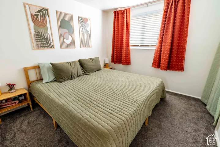 Neutral-toned interior room featuring wall-to-wall carpeting and a horizontal slat window treatment