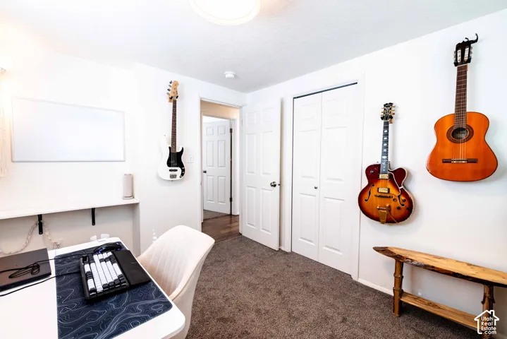 Interior space featuring wall-to-wall carpeting, a built-in recessed desk surface, and a double-door closet with paneled doors