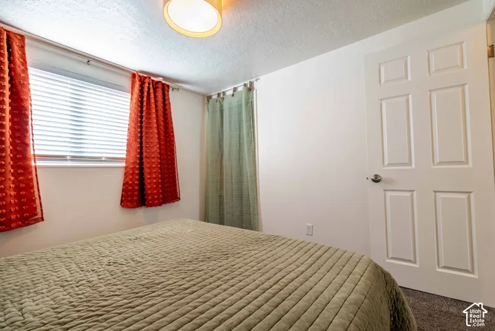 Neutral-toned interior space featuring a multi-panel interior door, recessed ceiling lighting, and a large horizontal window with slatted blinds