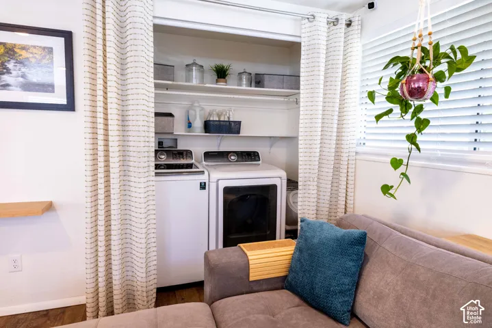 Laundry alcove featuring dual-level shelving and wood-finish flooring