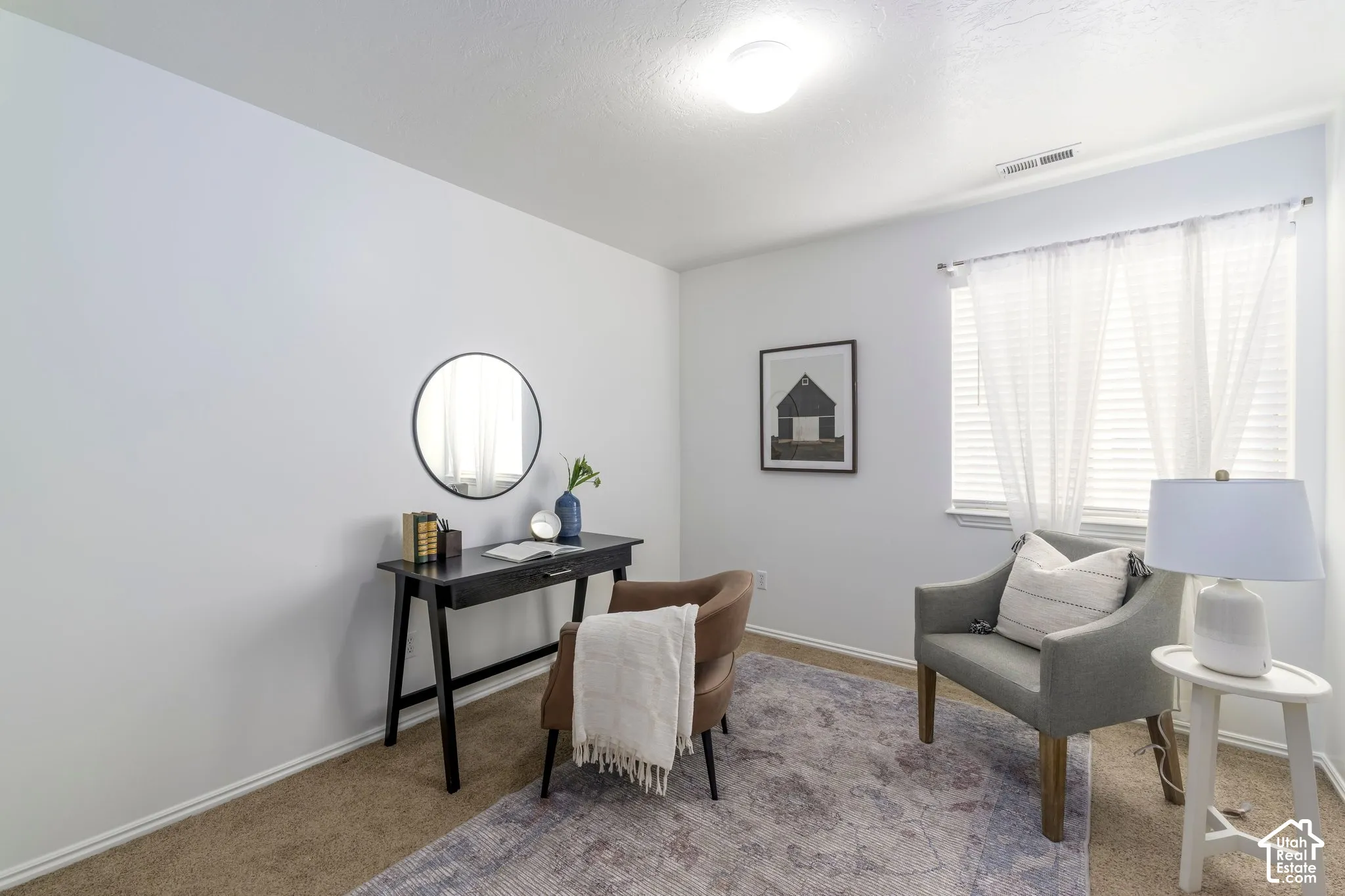 Neutral-toned interior space featuring wall-to-wall carpeting, a multi-pane window with horizontal blinds, and a flush-mount ceiling light fixture