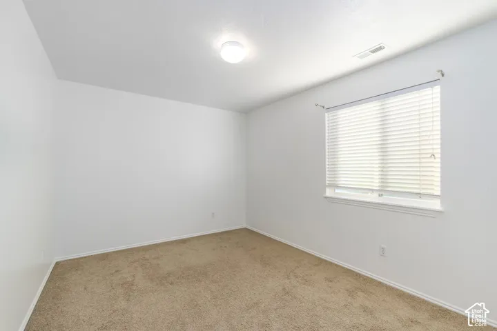 Neutral wall finish, carpeted flooring, and a single-pane window with horizontal blinds