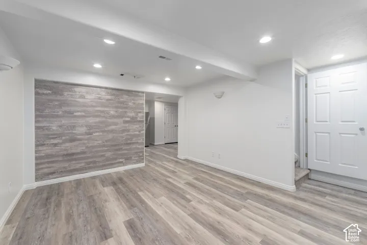 Interior space featuring wood-finish flooring, recessed lighting, and a textured wall accent