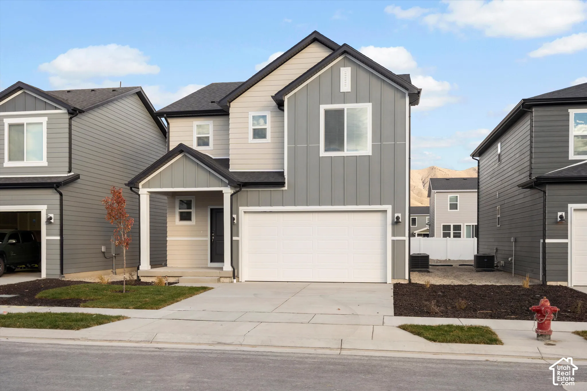 **DISCLAIMER** Elevation and exterior color may vary. Two-story exterior featuring a mix of vertical board-and-batten and horizontal siding, a covered front porch, and an attached two-car garage
