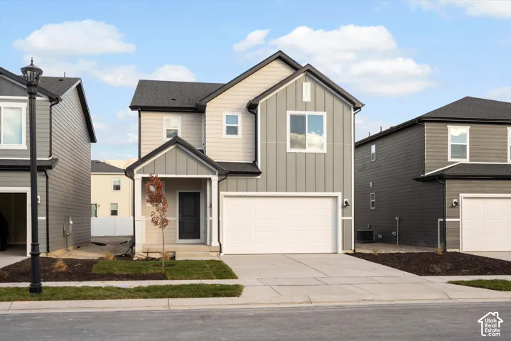 **DISCLAIMER** Elevation and exterior color may vary. Two-story exterior featuring vertical board-and-batten and horizontal lap siding, a front-facing gable roof, a covered porch entry, and an attached two-car garage