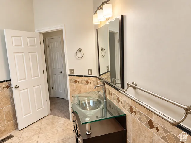 Main bathroom featuring custom vanity and tile