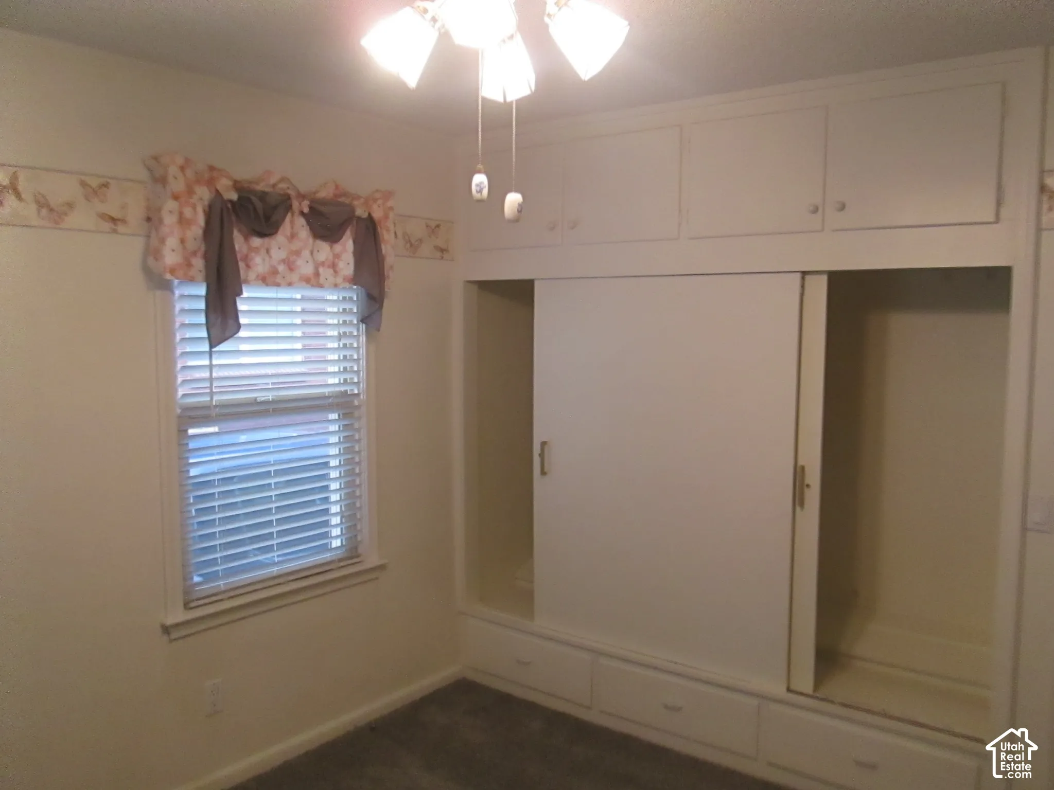 Built-in wall-to-wall cabinetry featuring overhead storage, sliding wardrobe doors, and lower drawer storage