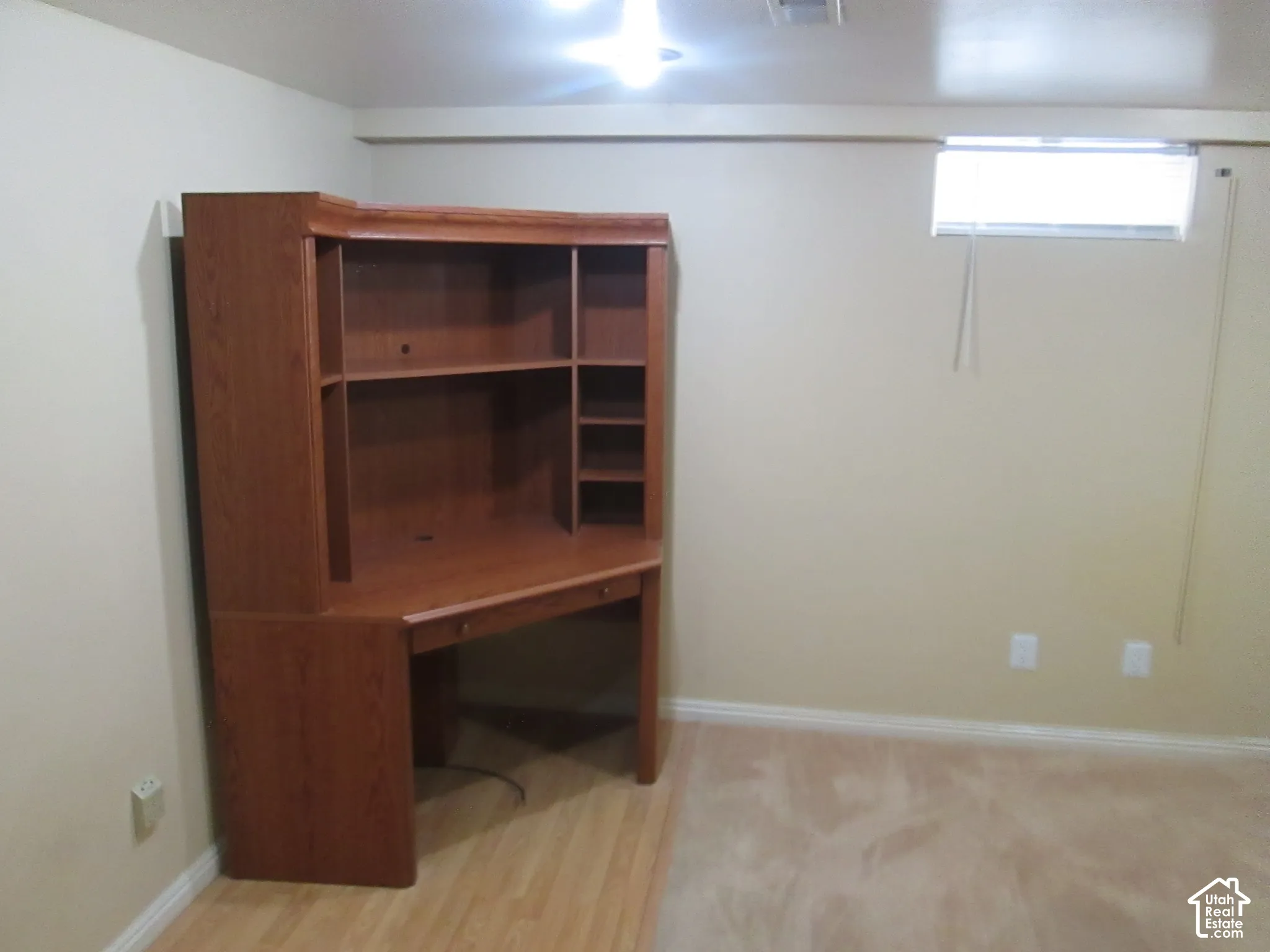 Room featuring neutral wall paint, carpeted flooring, and a horizontal window with blinds