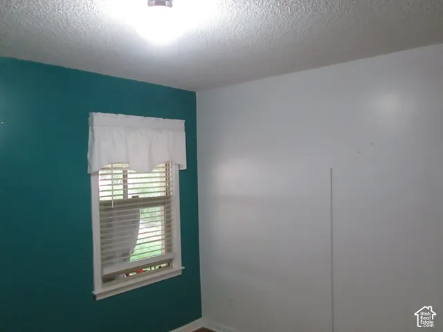 Room featuring dual-tone painted walls, a single-hung window, and installed horizontal window blinds
