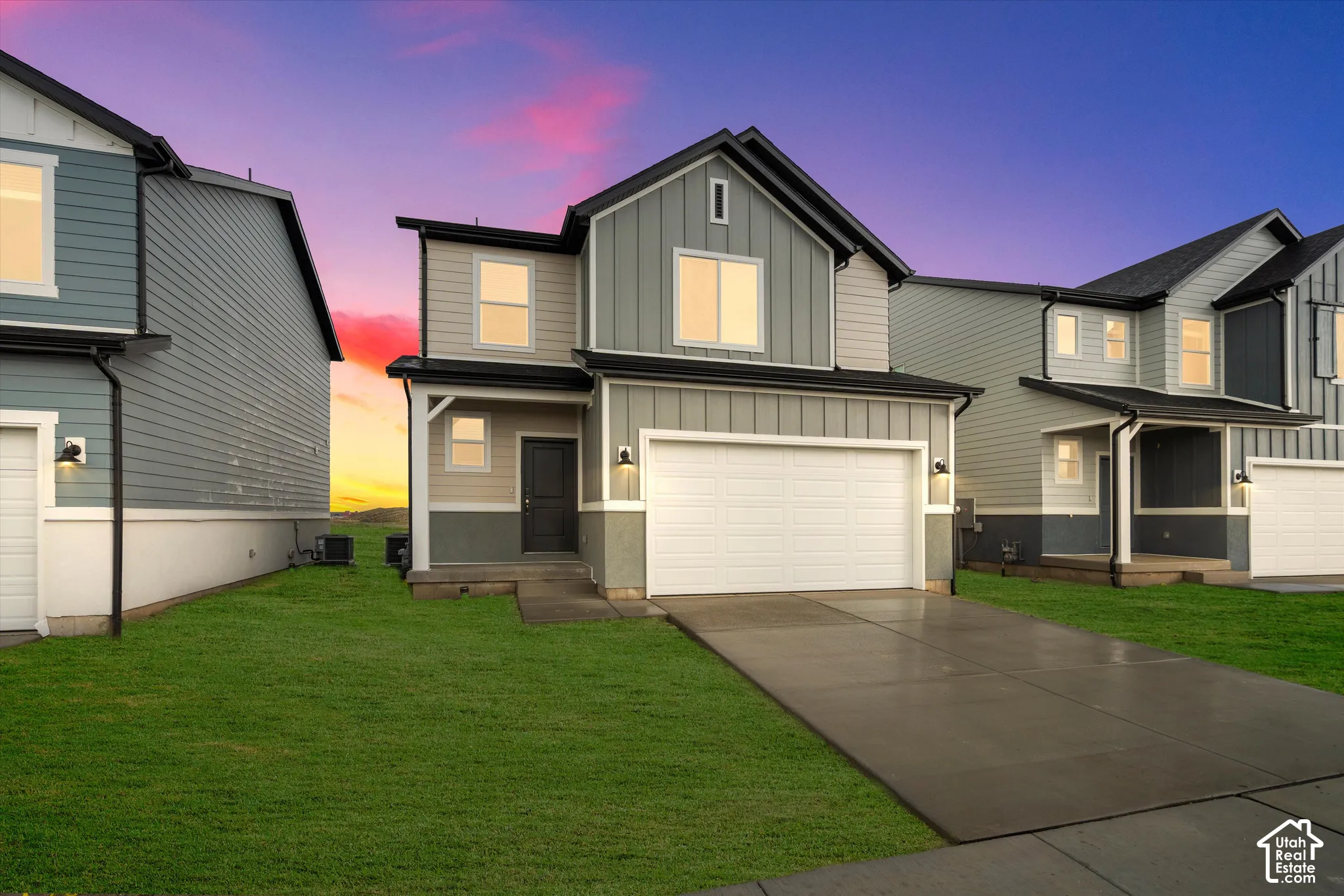 **DISCLAIMER** Elevation and exterior color may vary. Multi-level exterior featuring a mix of vertical board-and-batten and horizontal lap siding, an attached two-car garage, concrete driveway, and covered entryway