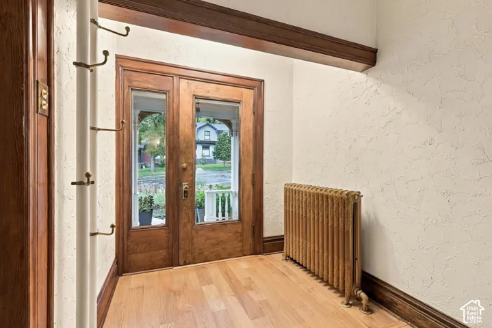 Entry with original hardwood and glass front door and powder-coated radiator.