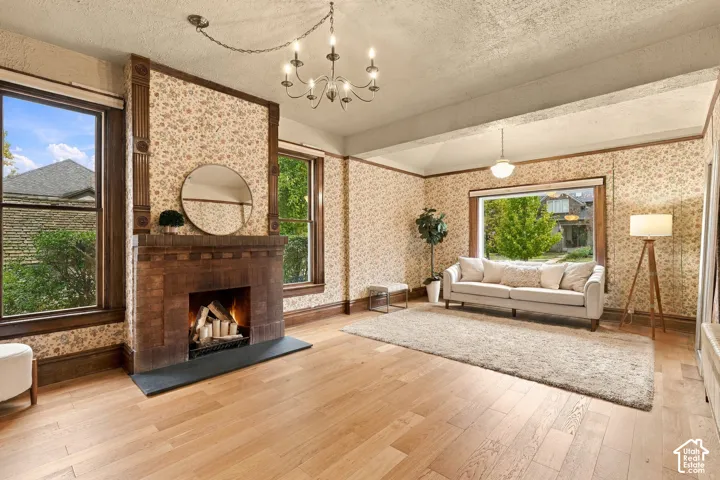 Spacious living room with fireplace, windows, and new oak flooring.