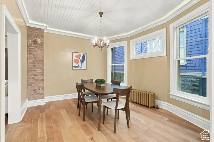 Stunning dining room with original exposed brick, gorgeous windows, powder-coated radiator, and new oak flooring.