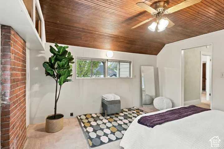 Bedroom with cool wood ceiling, exposed brick, and lots of windows.
