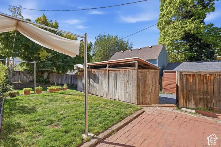 Back red-brick patio with gate to the covered carport.
