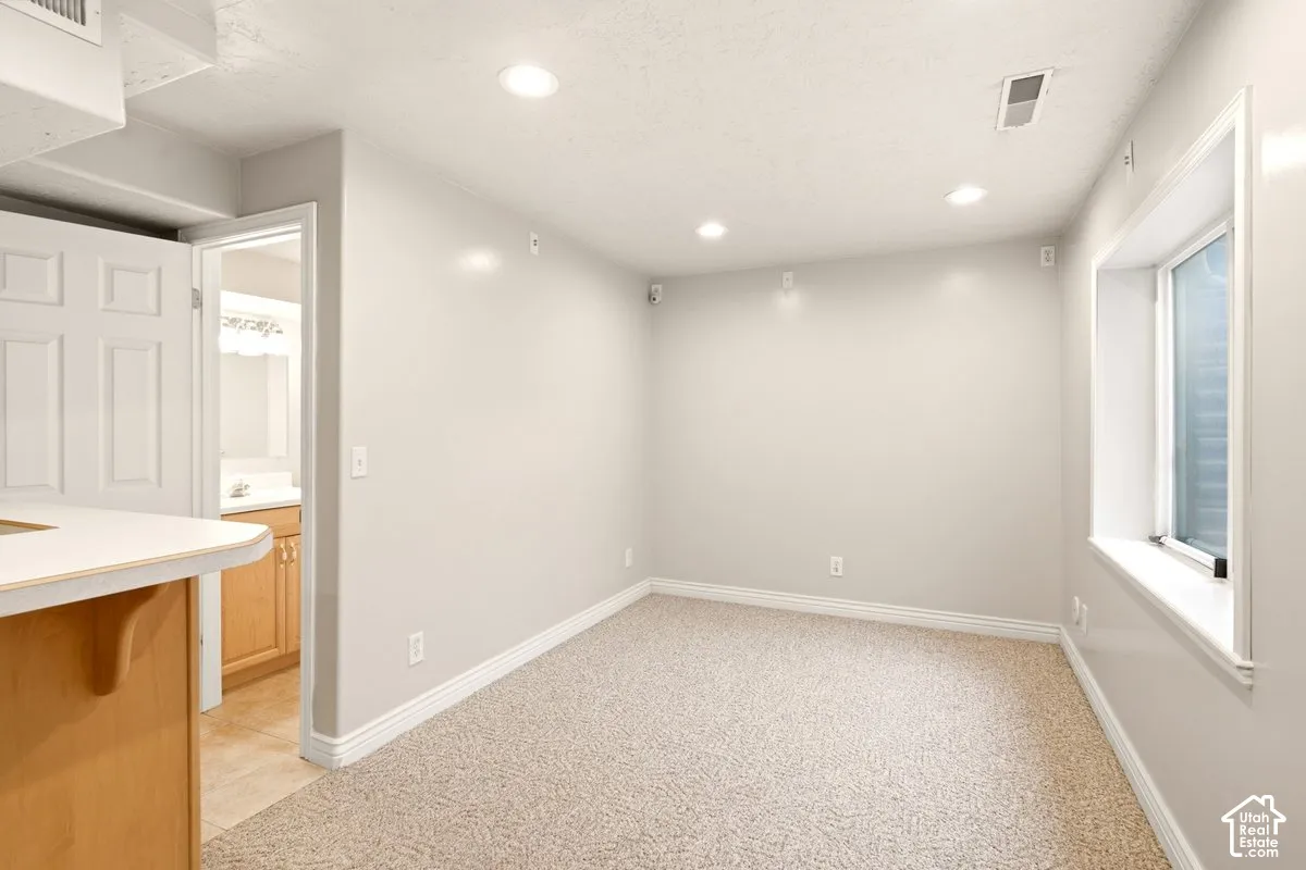 Interior space featuring neutral-toned carpeting, recessed lighting, and a recessed window with a deep sill