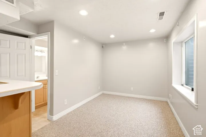 Interior space featuring neutral-toned carpeting, recessed lighting, and a recessed window with a deep sill