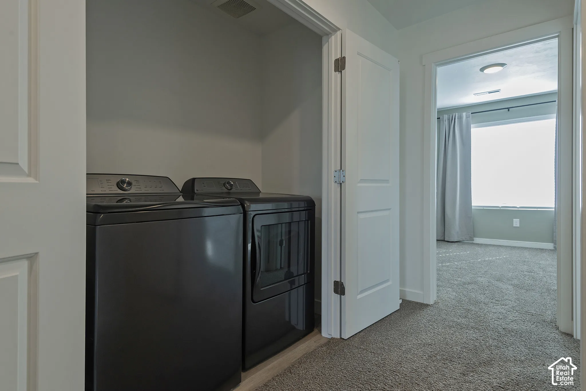 Laundry closet featuring a dedicated recessed area for appliances, neutral wall color, and white paneled doors