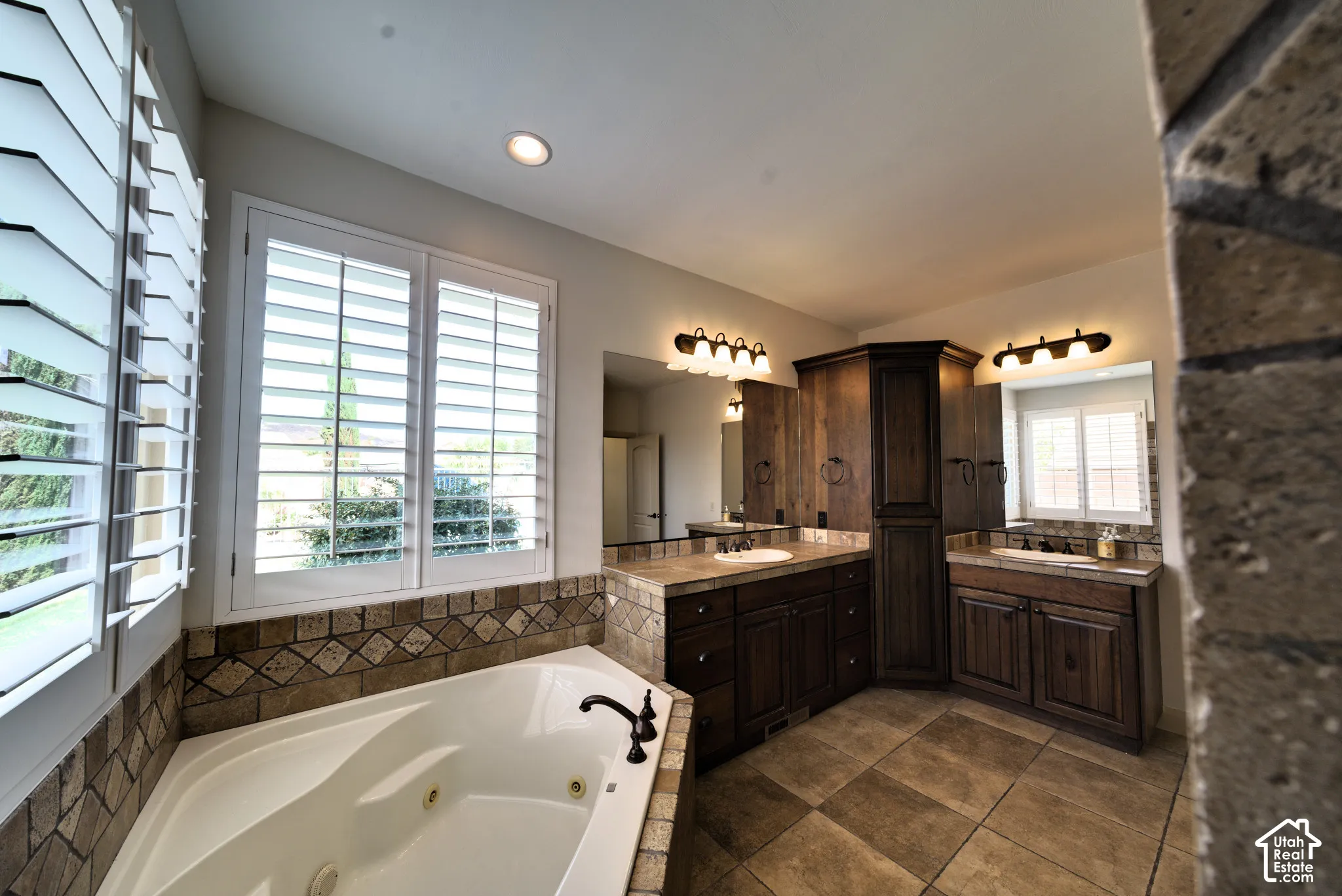 Primary bathroom vanities with a tall linen cabinet.
