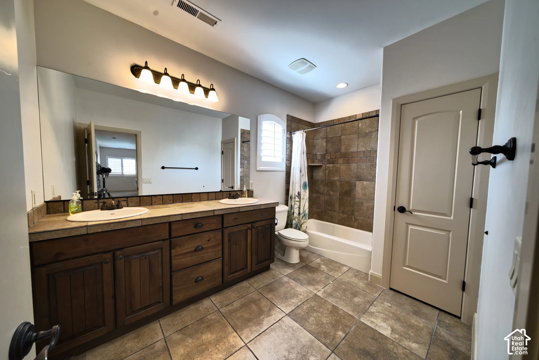 Upstairs full bathroom with two sinks and a tub and shower.