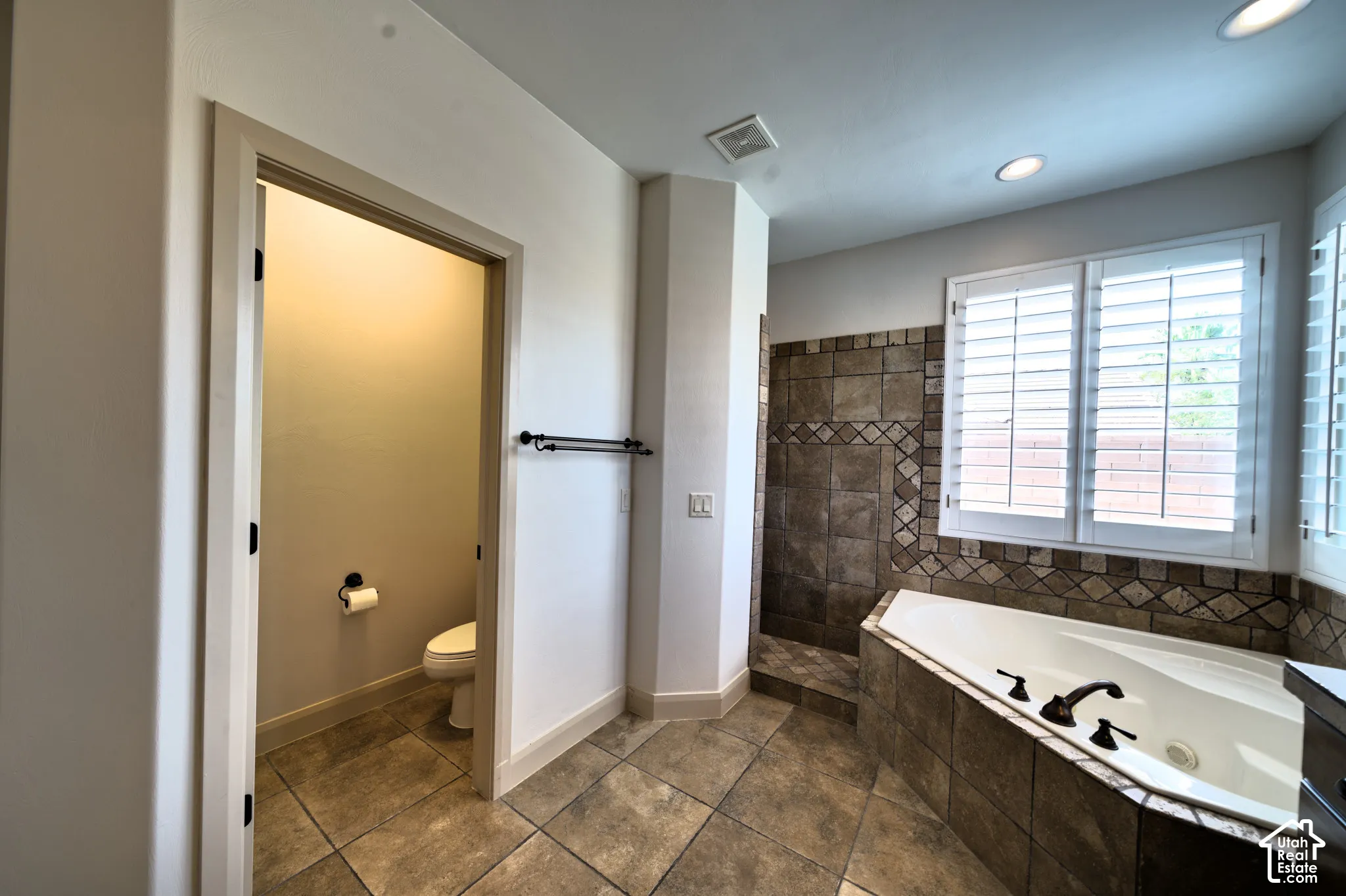 Private toilet room and corner jetted tub in the primary bathroom.